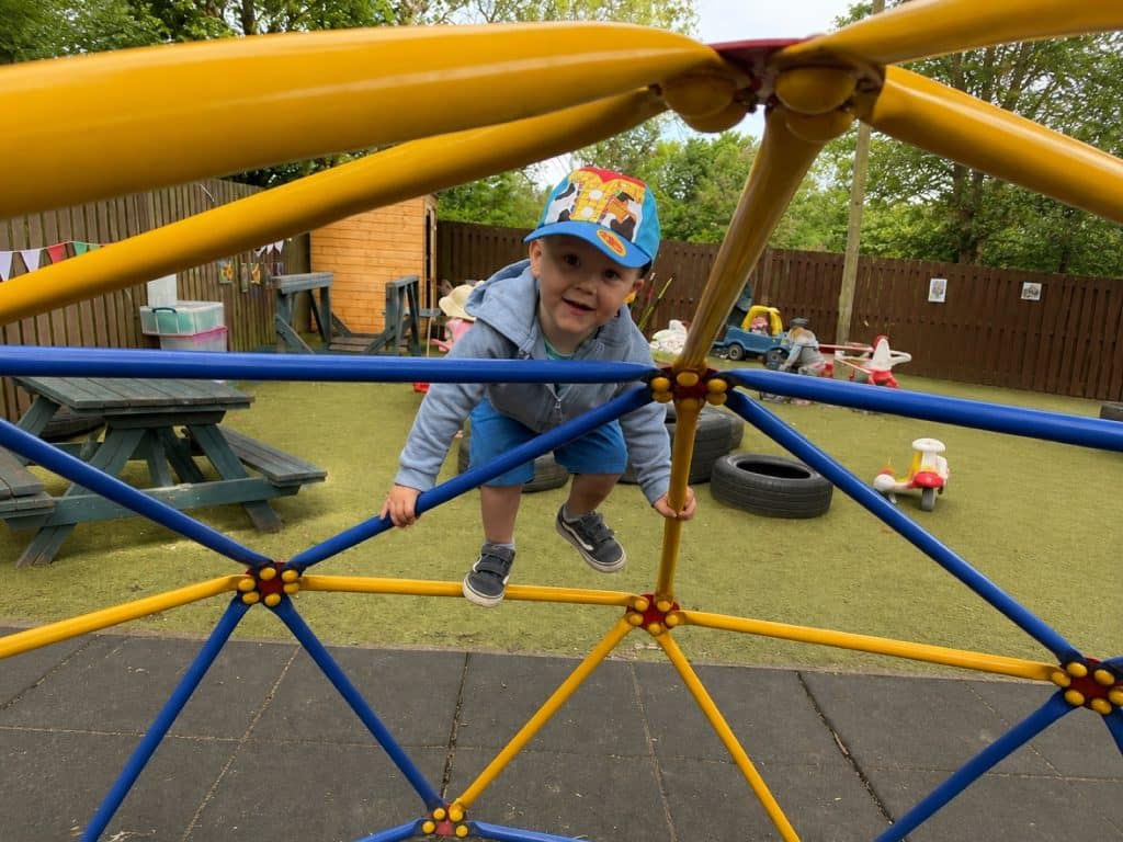 A child climbing on the outdoor climbing frame
