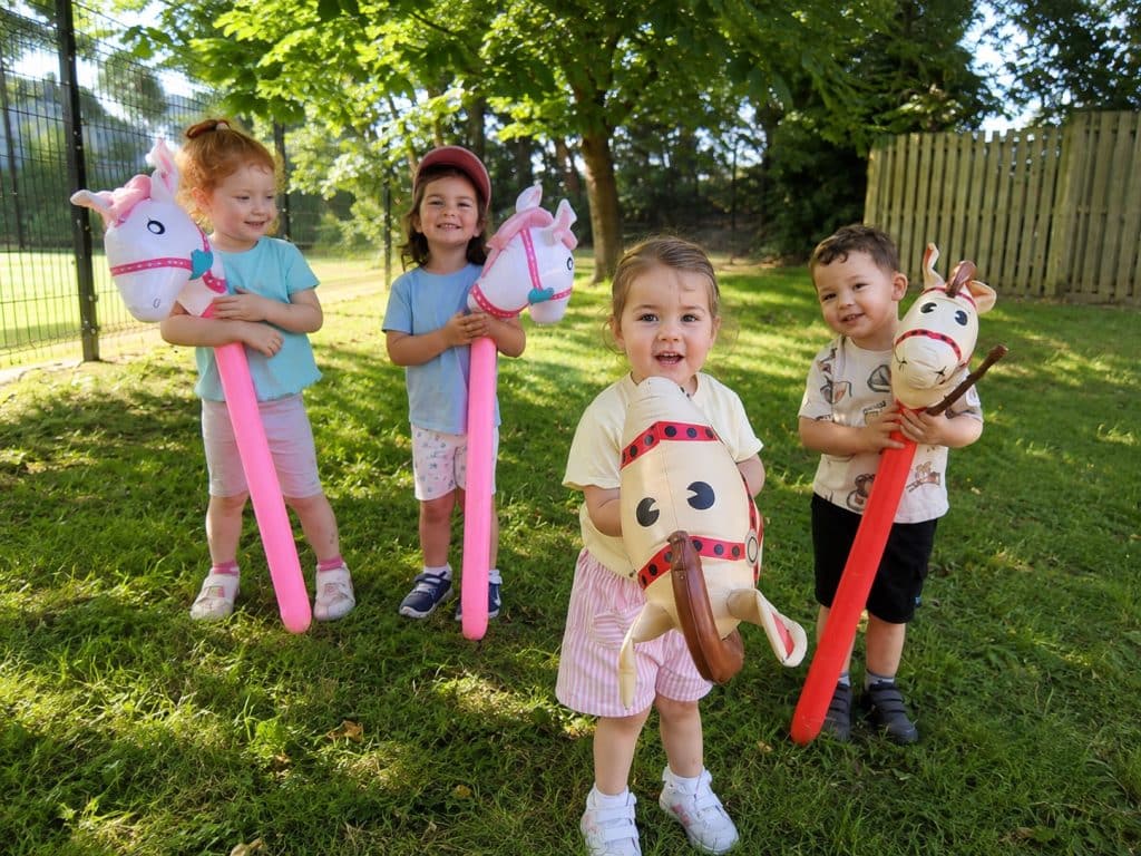 Children playing with hobby horses in the garden