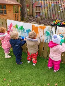 Painting together on the garden fence