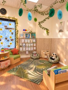 The book corner in Bright Blossoms - cushioned seating, a low book display and soft toys